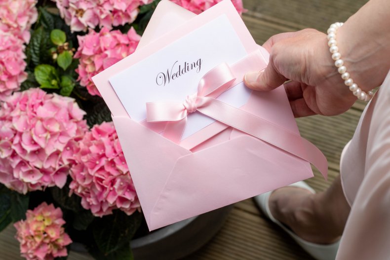 A pink wedding invitation card in envelope.