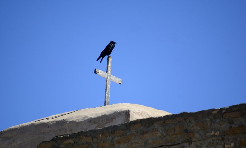 A raven sits on a cross 
