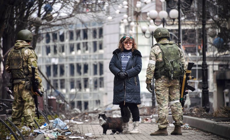 A woman talks with Russian soldiers