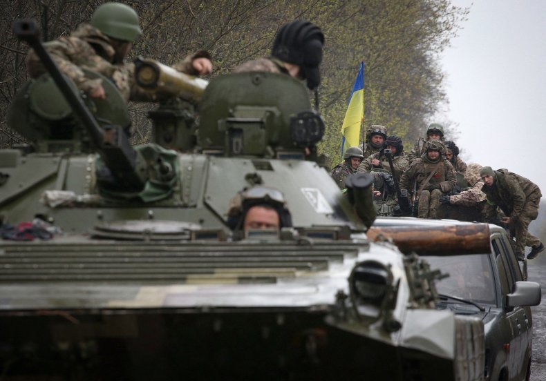Ukrainian soldiers stand on their APC