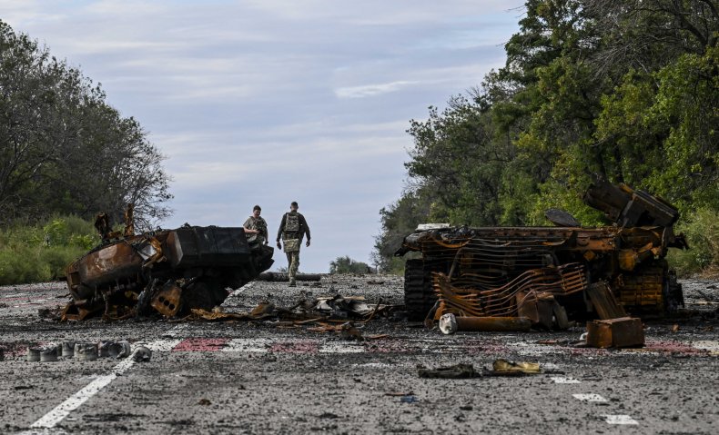 Destroyed armored vehicles litter the road 