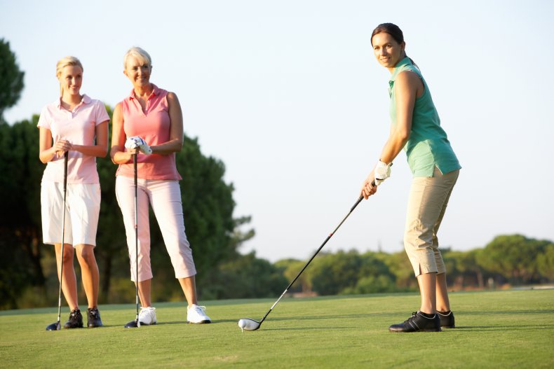 Women golfing on a course. 