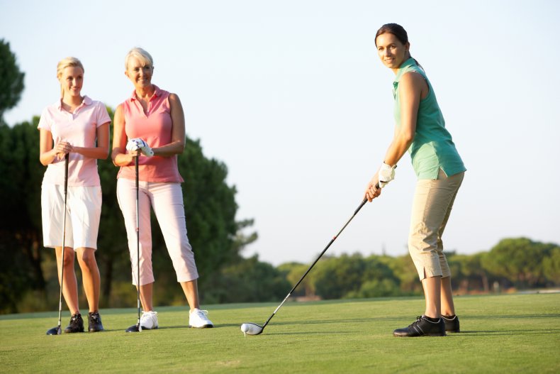 Women golfing on a course.