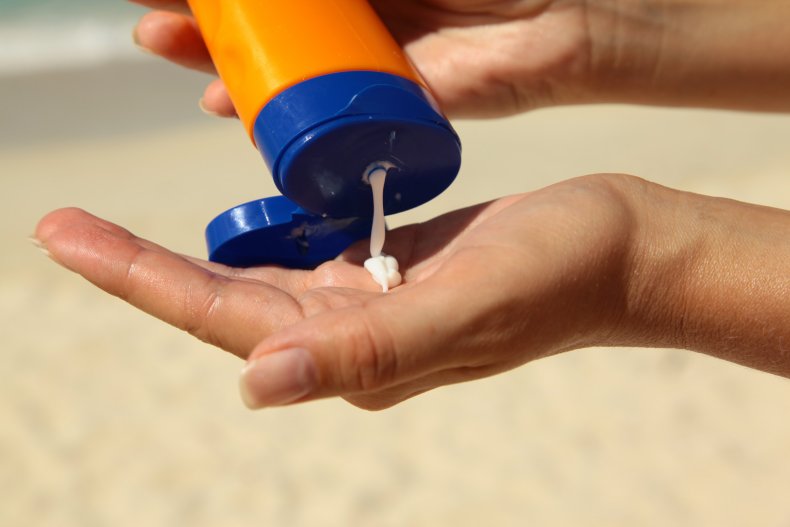 A woman holding sunscreen