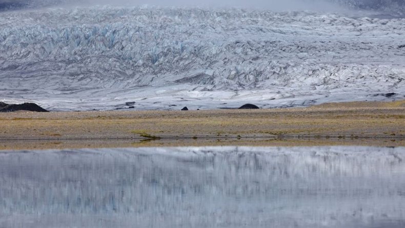 The Kviarjokull glacier creates a reflection in the lake
