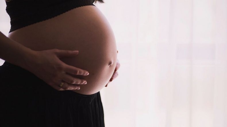 Mujer embarazada acaricia el vientre