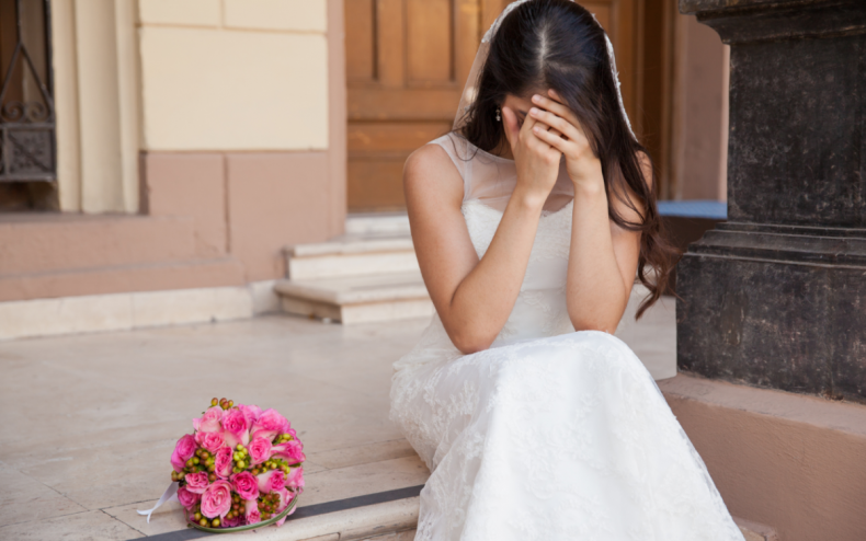 A woman in white on church steps.