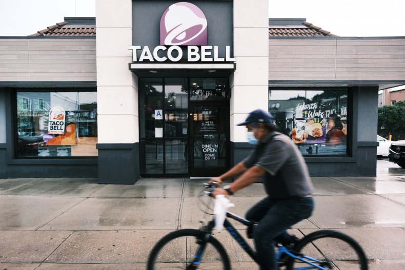 Bicyclist passes Taco Bell restaurant