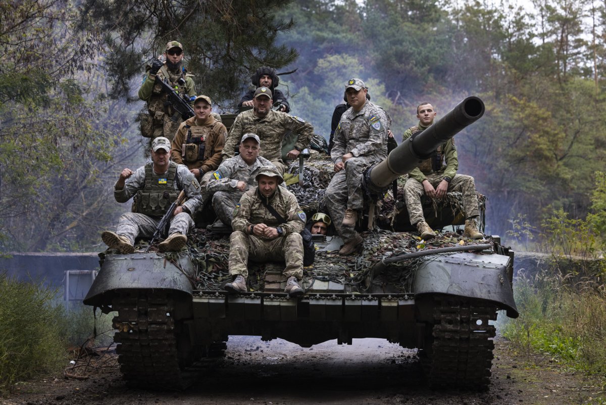 Ukrainian troops ride upon a Russian tank
