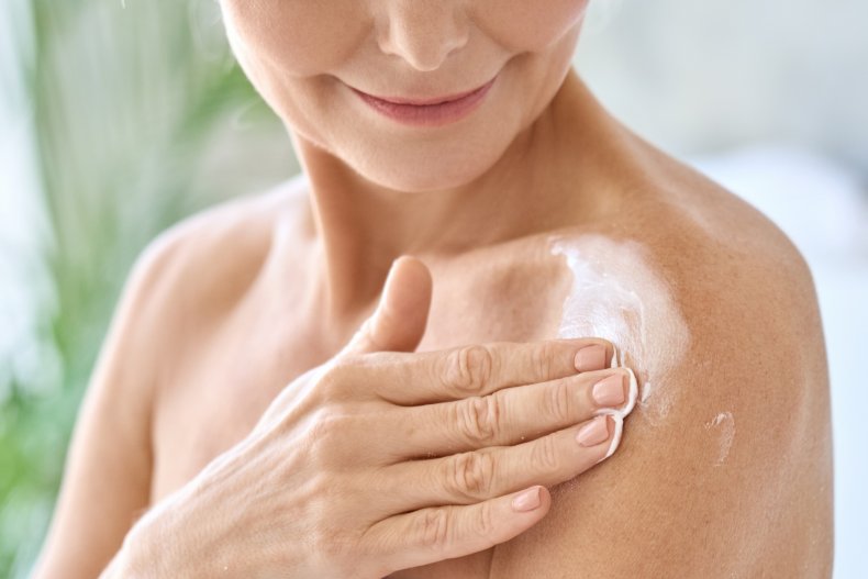 Una mujer aplicando una crema para la piel.