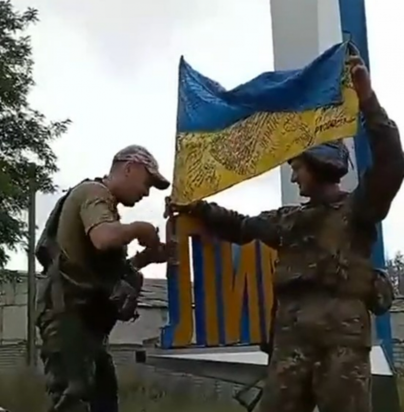 Ukrainian troops with flag in Lyman