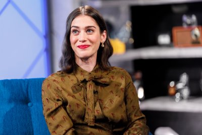 lizzy caplan sitting on sofa smiling lizzy caplan sitting on sofa smiling