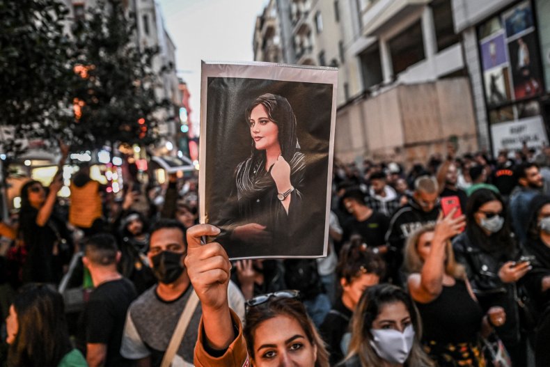 Protester holds a portrait of Mahsa Amini