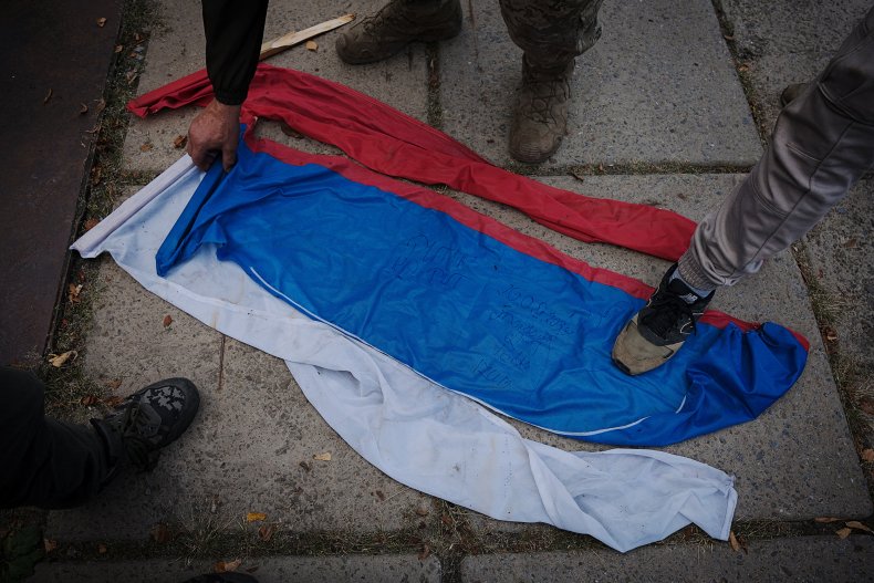 Soldados ucranianos pisotean banderas rusas en tierra 