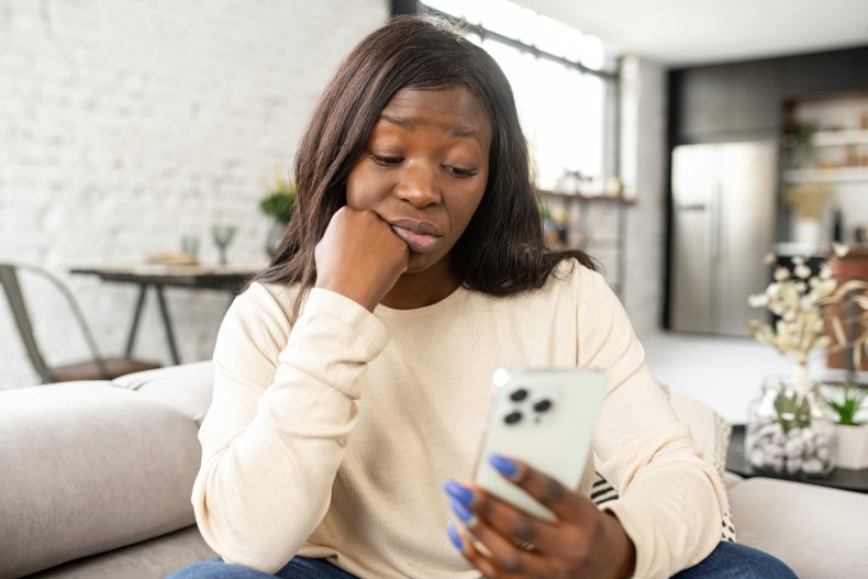 Angry woman looks at her phone