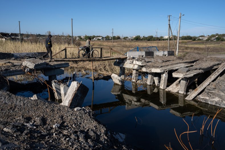 Men cross a makeshift bridge in Ukraine
