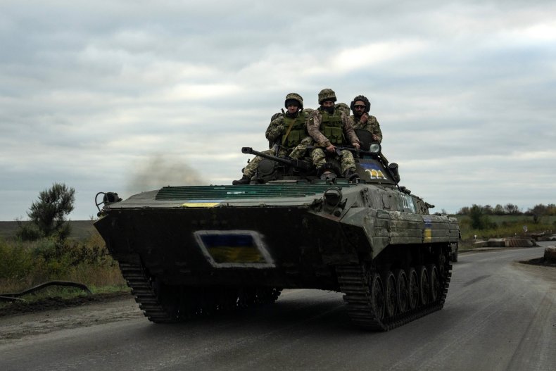 Ukrainian soldiers ride atop a tank