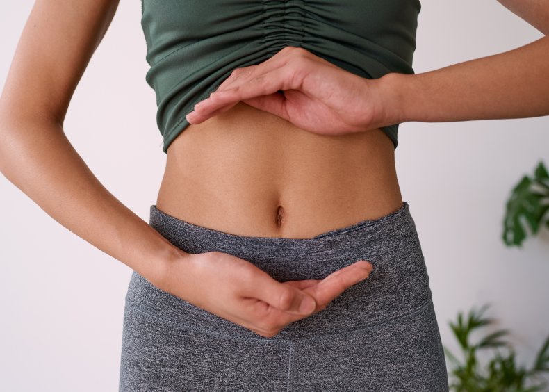 Woman holds hands around healthy gut