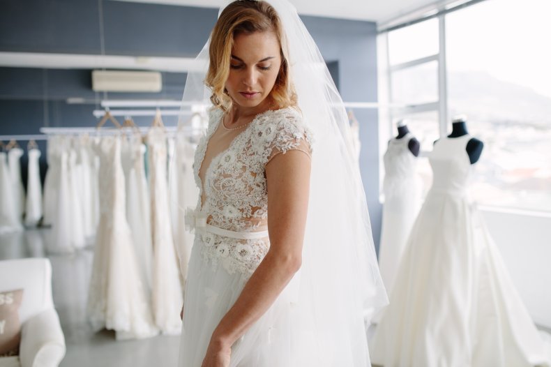 Woman trying on wedding dress at shop. 