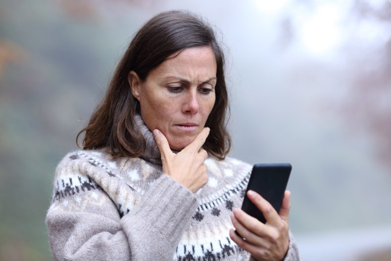 A woman looking upset at her phone