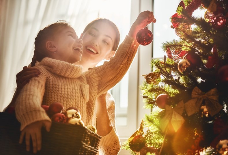 Wanita dan gadis muda menghias pohon Natal.