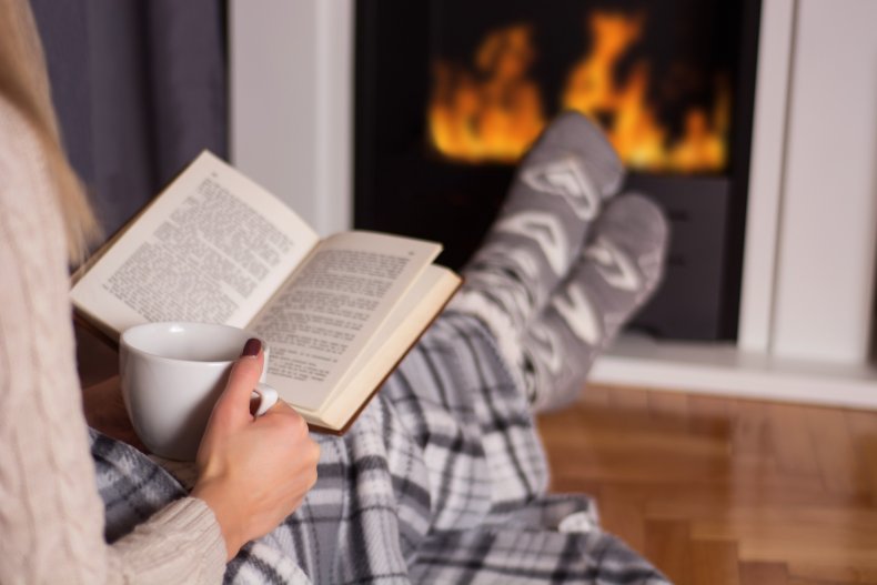 Woman reading by the fire