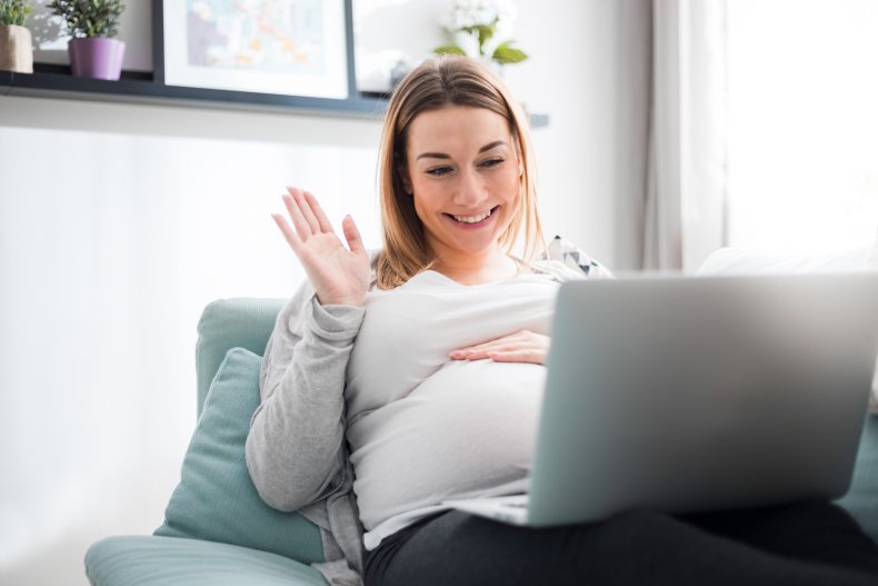 Pregnant woman waving during video call.