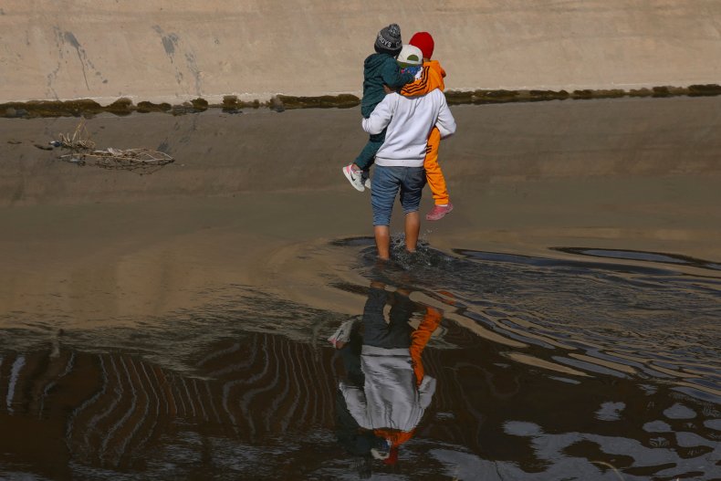 A migrant helps two Venezuelan children 