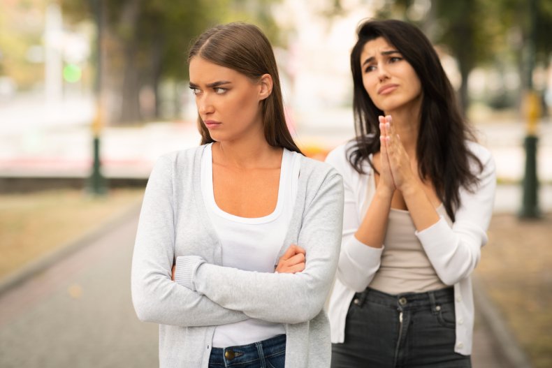 Woman ignoring her pleading friend