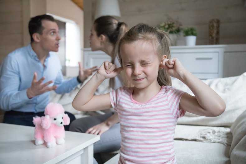 Girl with ears closed, as couple fight.