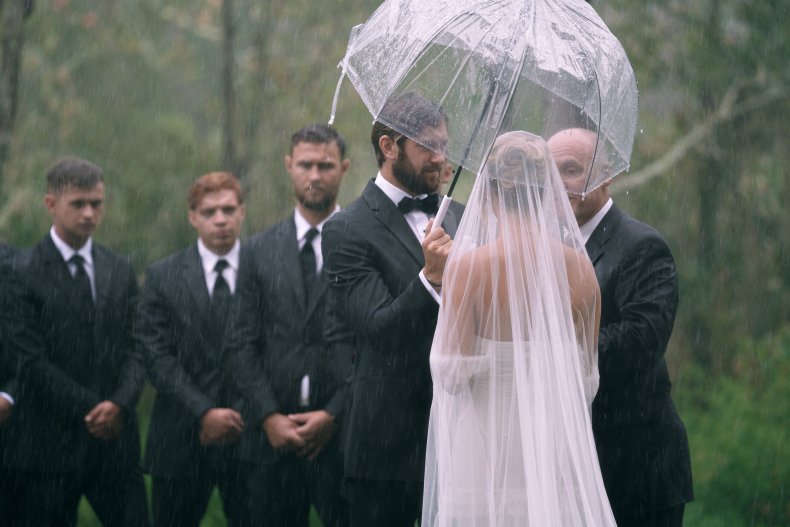 The couple stand in front of groomsmen