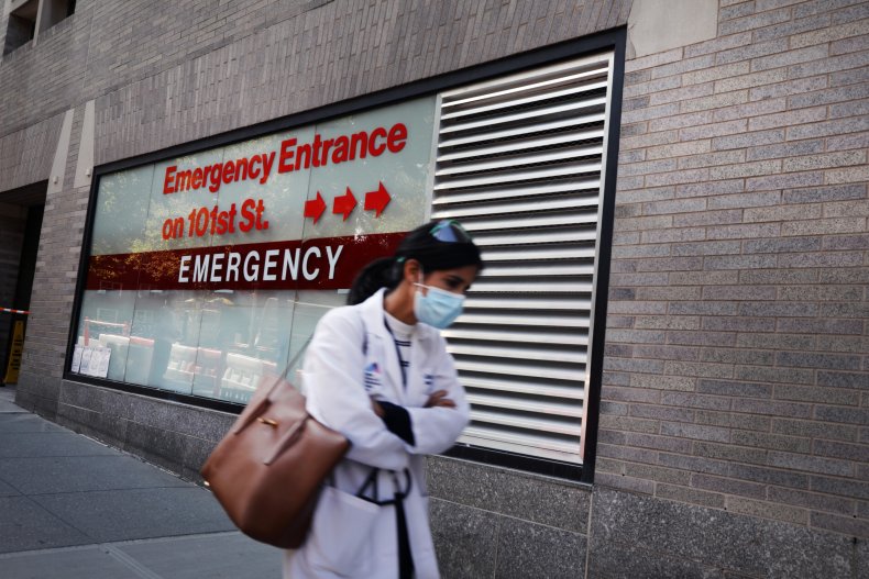 A person walks past "Emergency Entrance" sign