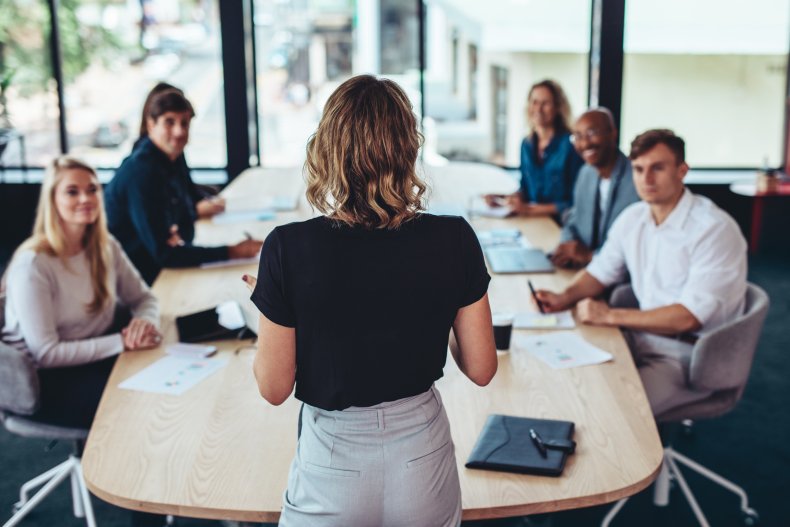 Worker speaking at table in office.
