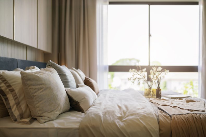 Several pillow seen on a bed.