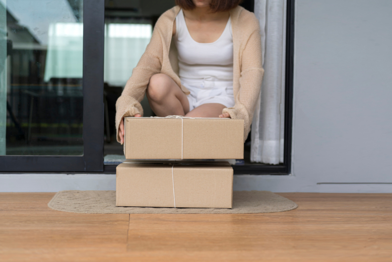 Woman picking up parcels left on porch
