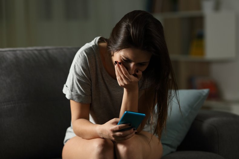 Woman staring at her phone in horror