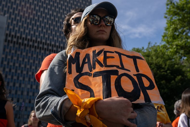 A couple holds a sign