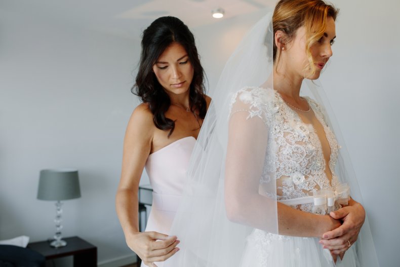 Bridesmaid helps bride with veil