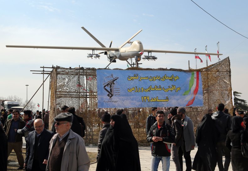Iranians walk past Iran's Shahed 129 drone 