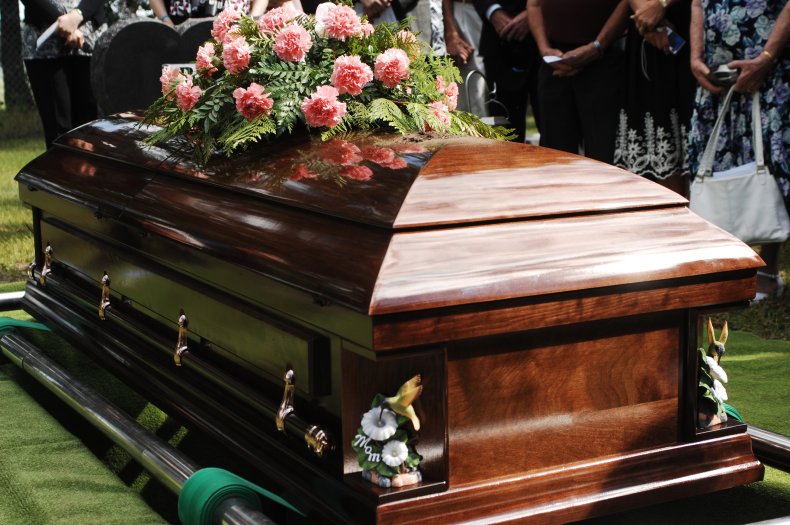 A wooden casket at an outdoor funeral