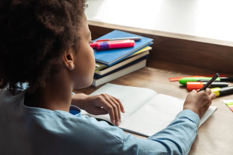 A black girl working at a desk.