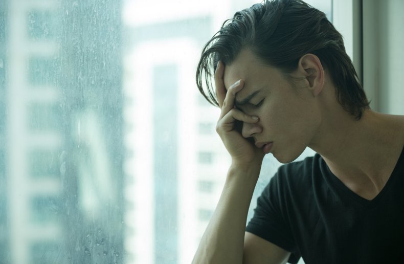 Upset teenage boy with head in hands
