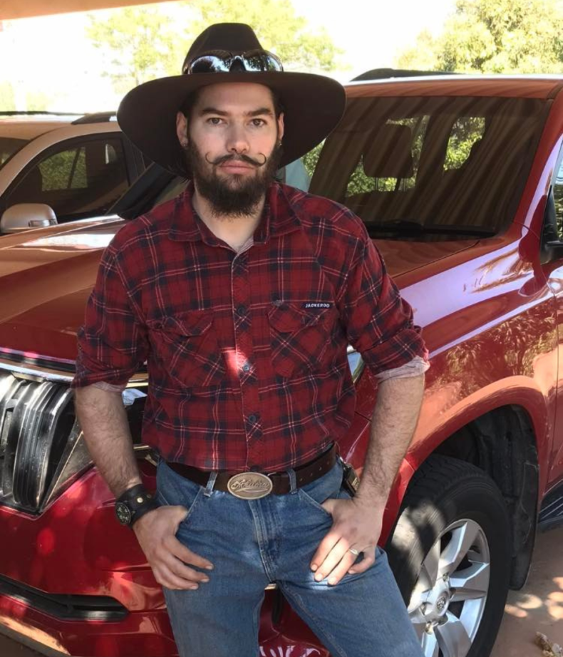 Weis, pre-transition, in front of a Jeep
