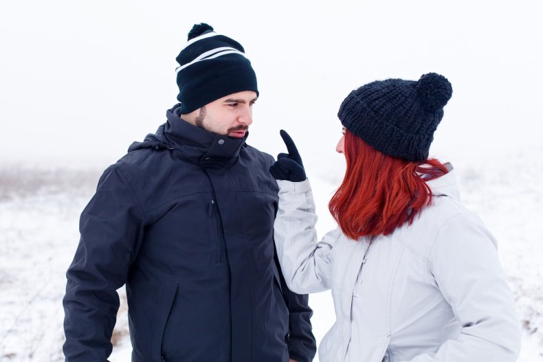 Couple dressed in winter clothing arguing