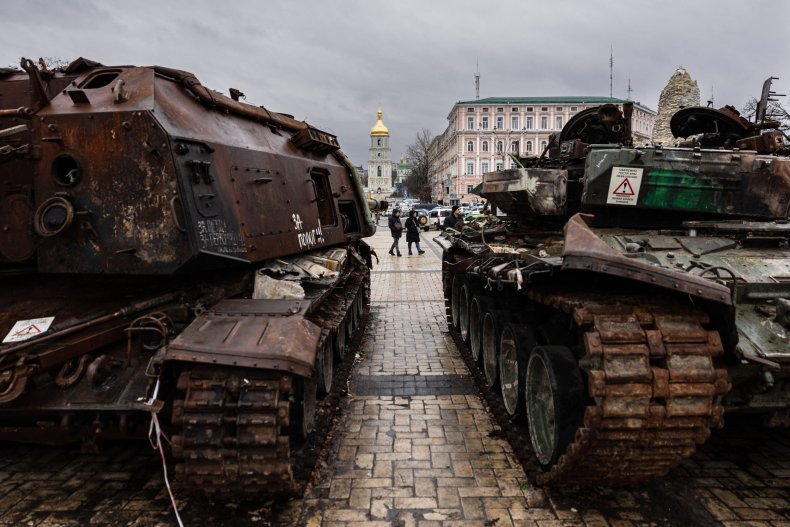 Pedestrians look at destroyed Russian military vehicles