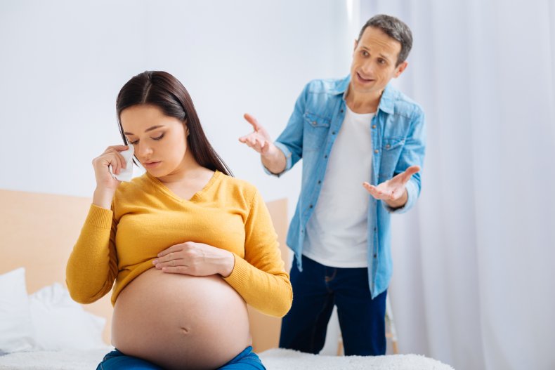 Husband pleading with his crying, pregnant wife