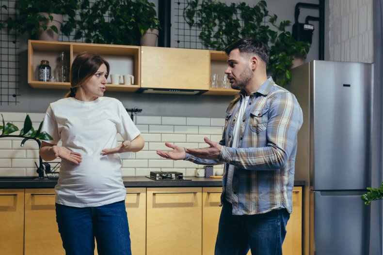 Pregnant woman and husband arguing in kitchen