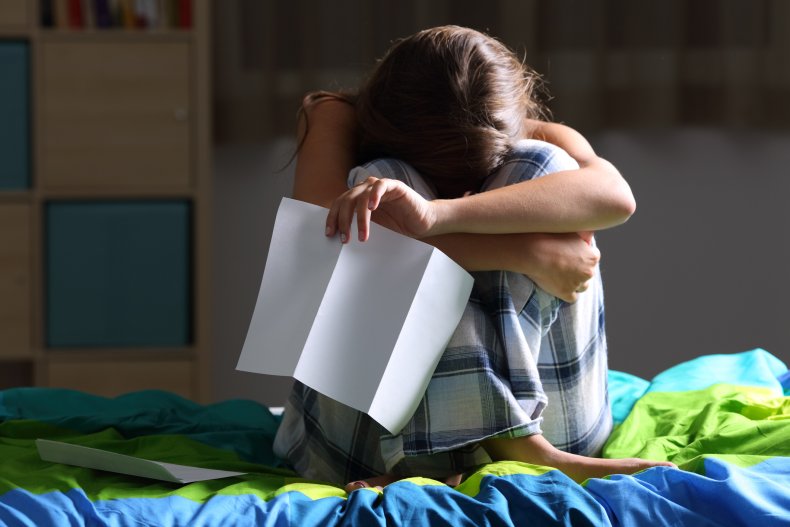 Teenage girl crying on her bed