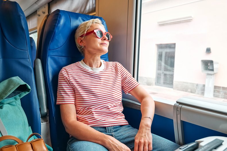 Woman in sunglasses aboard a train. 