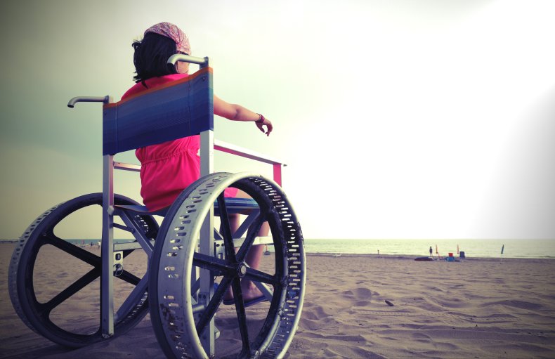 A child in a wheelchair on beach.